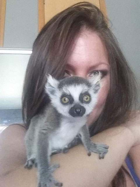 Woman with lemur on arm